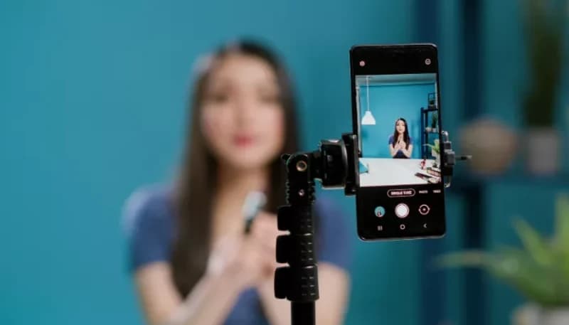 Woman recording a video on her phone, creating user-generated content.